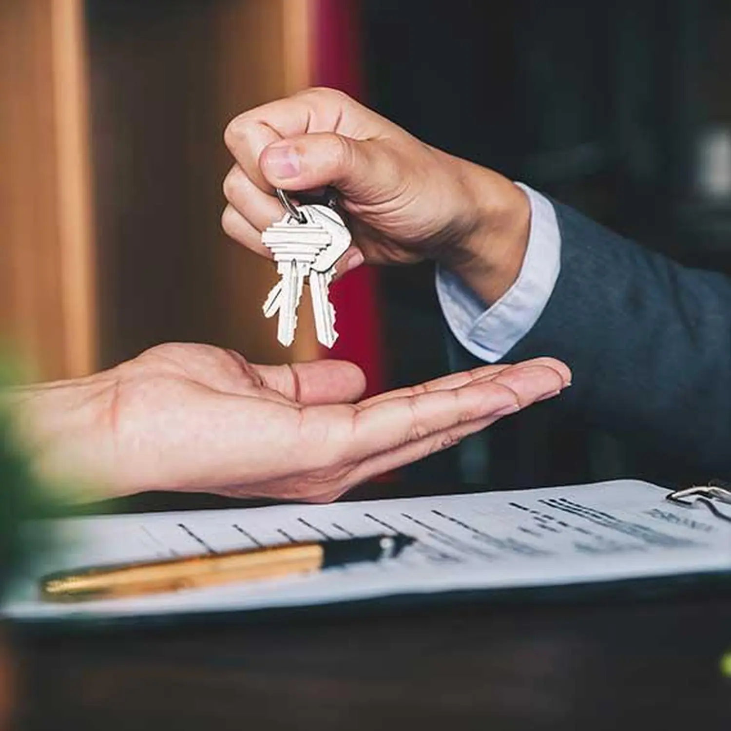 DME Immobilien, Geschäftsmann bei der Schlüsselübergabe an einen Kunden